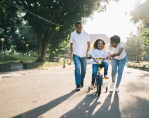 parents teaching their child to ride a bike